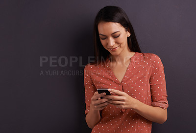 Buy stock photo Woman, cellphone and texting communication in studio for online conversation or social media, scroll or internet. Female person, smartphone and grey background or contact us, network or mockup space