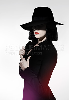 Buy stock photo Studio shot of a mysterious woman wearing a hat against a gray background