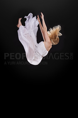 Buy stock photo Studio shot of a woman falling upside down against a black background