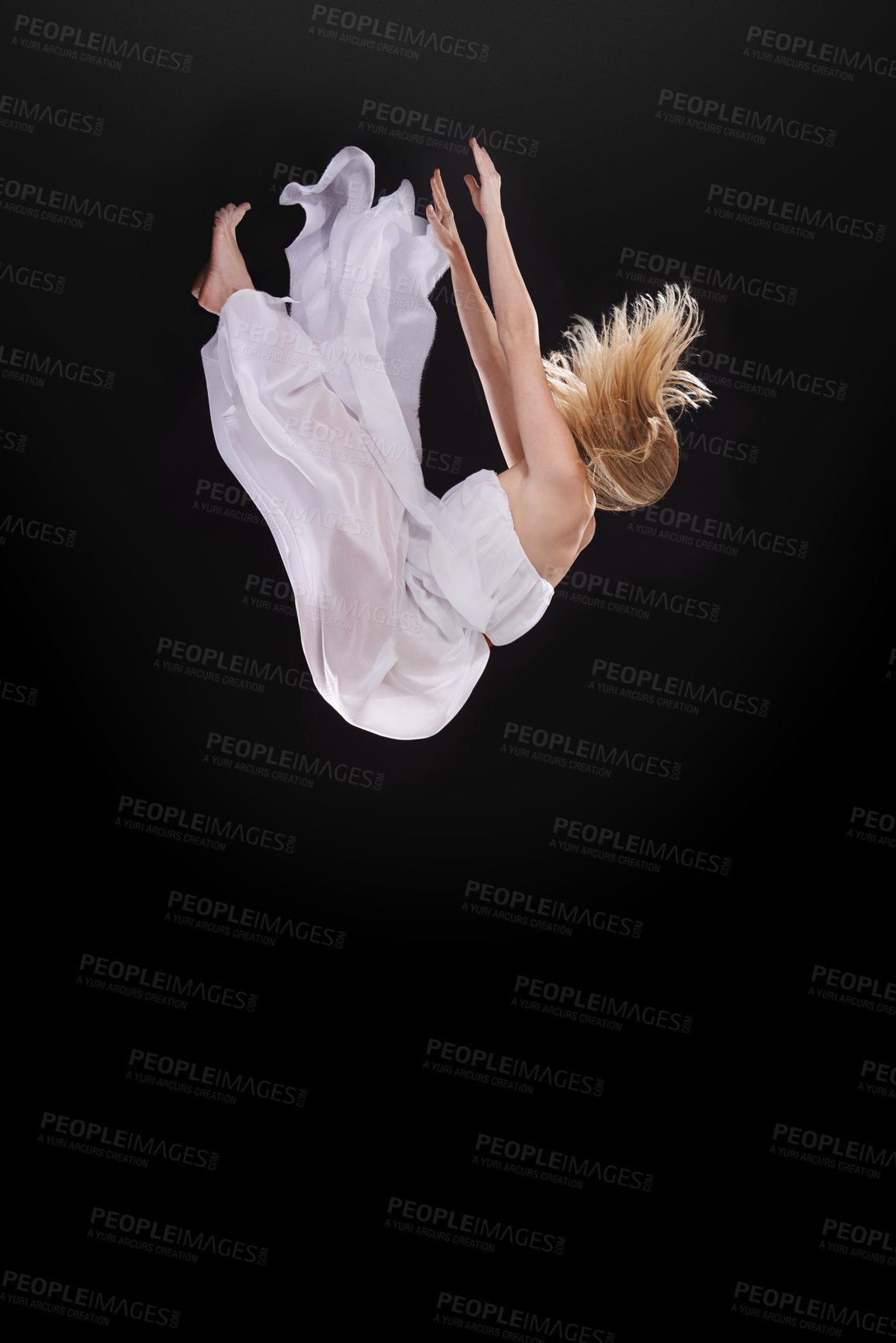 Buy stock photo Studio shot of a woman falling upside down against a black background