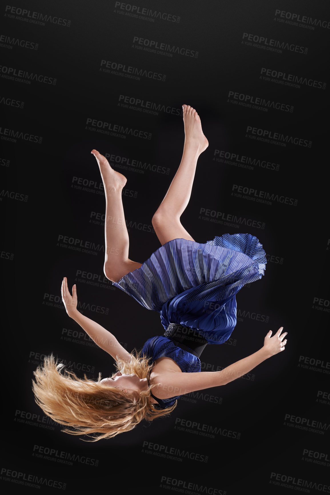 Buy stock photo Studio shot of a woman falling upside down against a black background