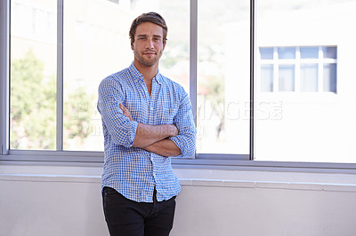 Buy stock photo Portrait of a handsome young man standing with his arms crossed,