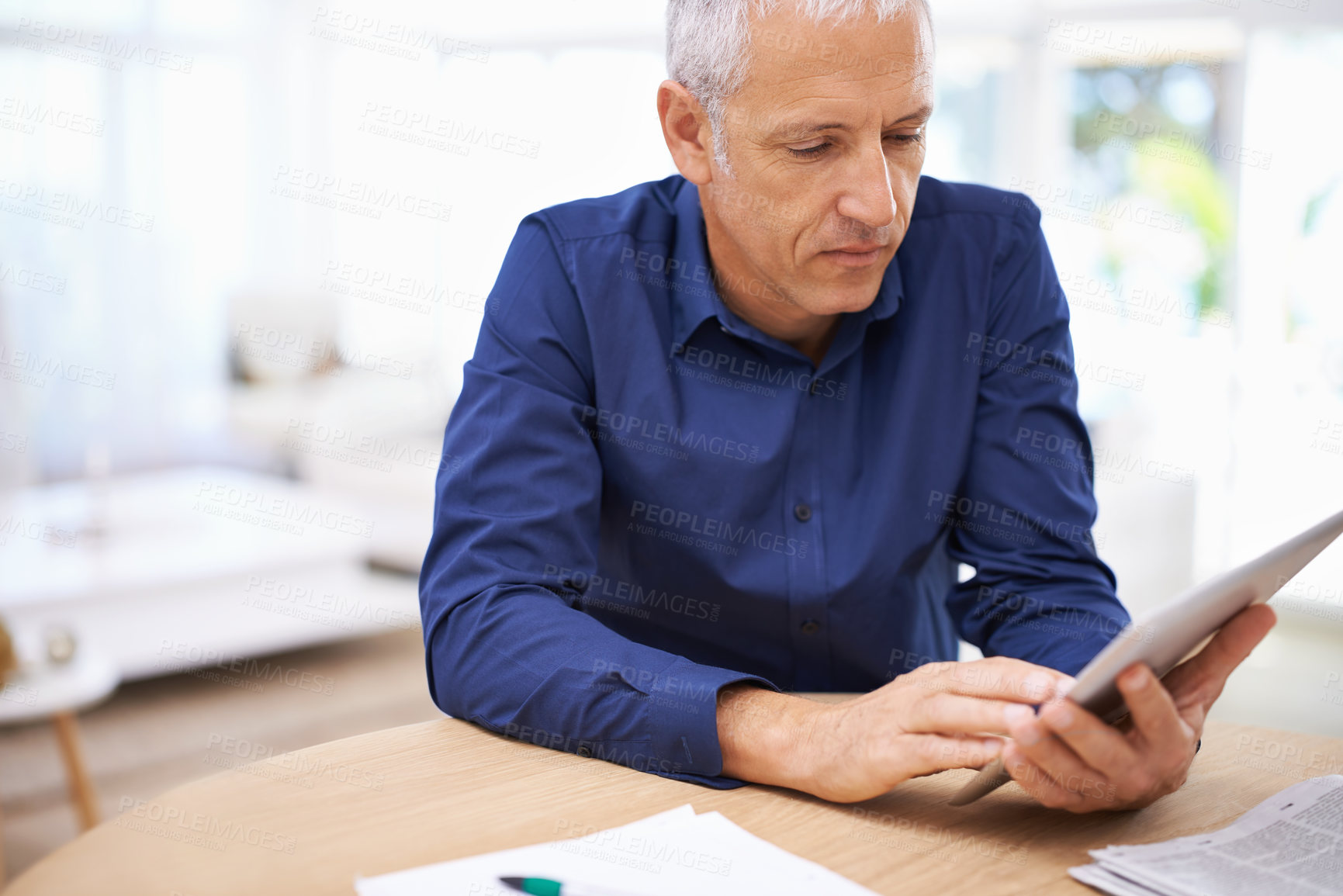 Buy stock photo Shot of a mature man using a digital tablet at home