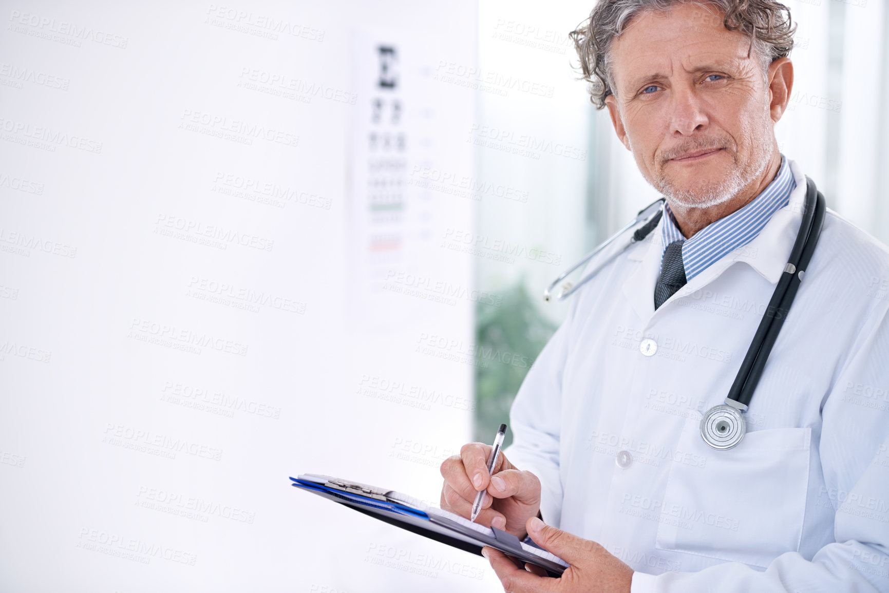 Buy stock photo Portrait of a mature optometrist standing in front of an eye chart