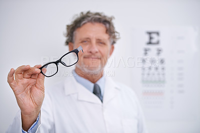Buy stock photo Portrait of a mature optometrist holding a pair of glasses