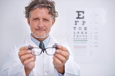 Buy stock photo Glasses, test and portrait of optometrist in clinic to check vision and eye exam in healthcare. Mature, doctor and reading letters on wall in medical assessment or consultation for contact lenses