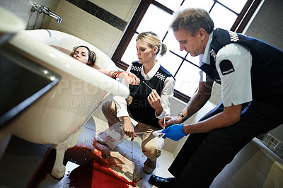 Buy stock photo Shot of two forensic specialists inspecting a body submerged in a bathtub
