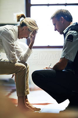 Buy stock photo Shot of a grief stricken woman giving her statement to a police officer at a crime scene
