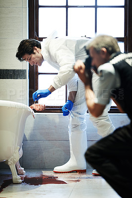 Buy stock photo Shot of two investigators working their way through a bloody crime scene