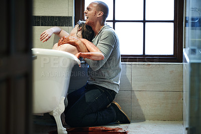 Buy stock photo Shot of a distraught man dragging a nude woman with a slit wrist out of a bathtub