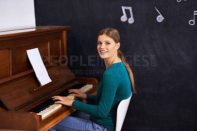 Buy stock photo Shot of a woman playing the piano against a background of musical notes
