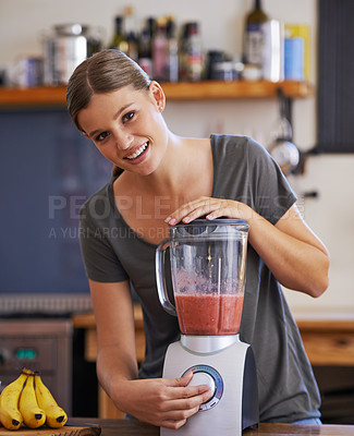Buy stock photo Portrait of an attractive young woman preparing a fruit smoothie