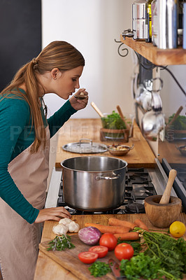 Buy stock photo Woman, cooking and vegetable at stove or tasting meal in kitchen for vegetarian dinner, nutrition or raw ingredients. Female person, appliance and pot in apartment for detox lunch, prepare or apron