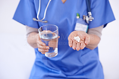 Buy stock photo Shot of a female doctor holding medication and glass of water