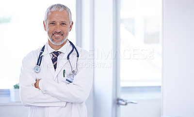 Buy stock photo Portrait of a doctor standing in a well-lit room with his arms crossed