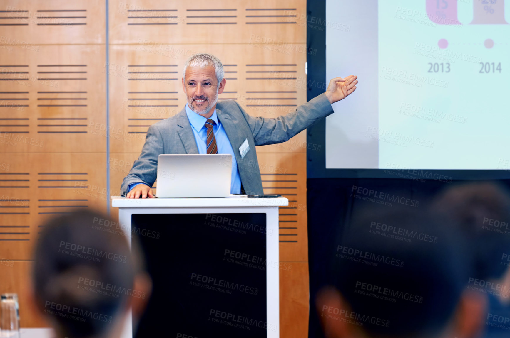 Buy stock photo A mature businessman gesturing while giving a presentation at a press conference