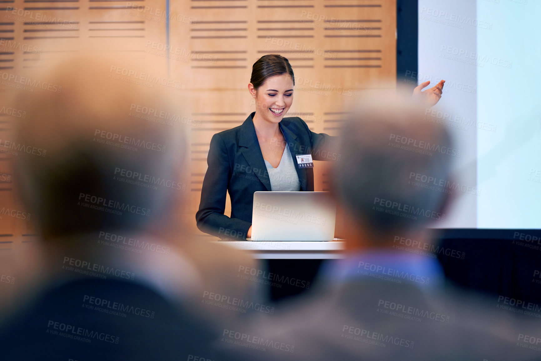 Buy stock photo Happy woman, presentation and laptop with projector at conference in team meeting, staff training or seminar. Young female person, employee or speaker talking on podium to group for business workshop