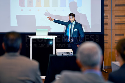 Buy stock photo A handsome businessman gesturing while giving a presentation at a press conference