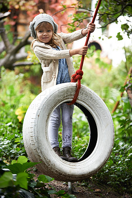 Buy stock photo Portrait, young girl and swing in garden, nature and entertainment in playground. Child, freedom and tyre for childhood development in forest, woods or park on weekend or holiday in autumn season