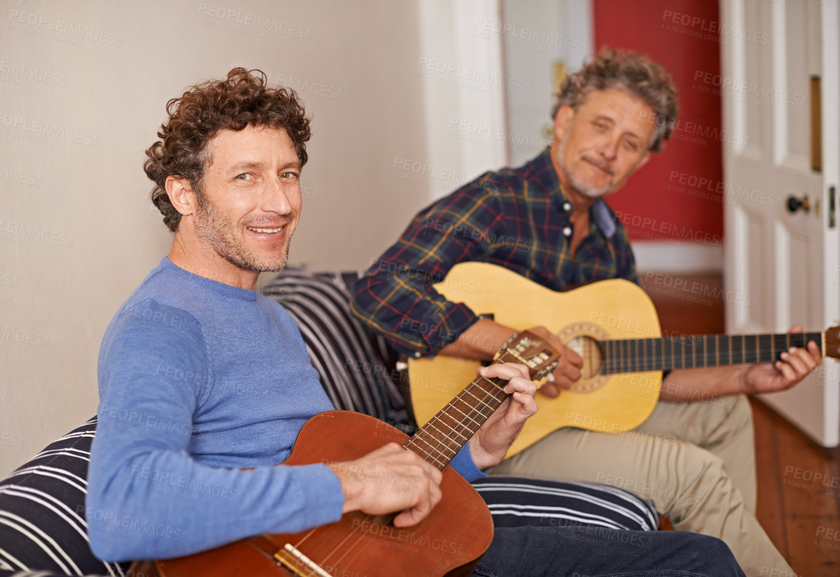Buy stock photo Happy man, portrait and relax with family, guitar or music for acoustic sound or instruments at home. Young man playing or strumming with smile and father for classical audio on living room sofa