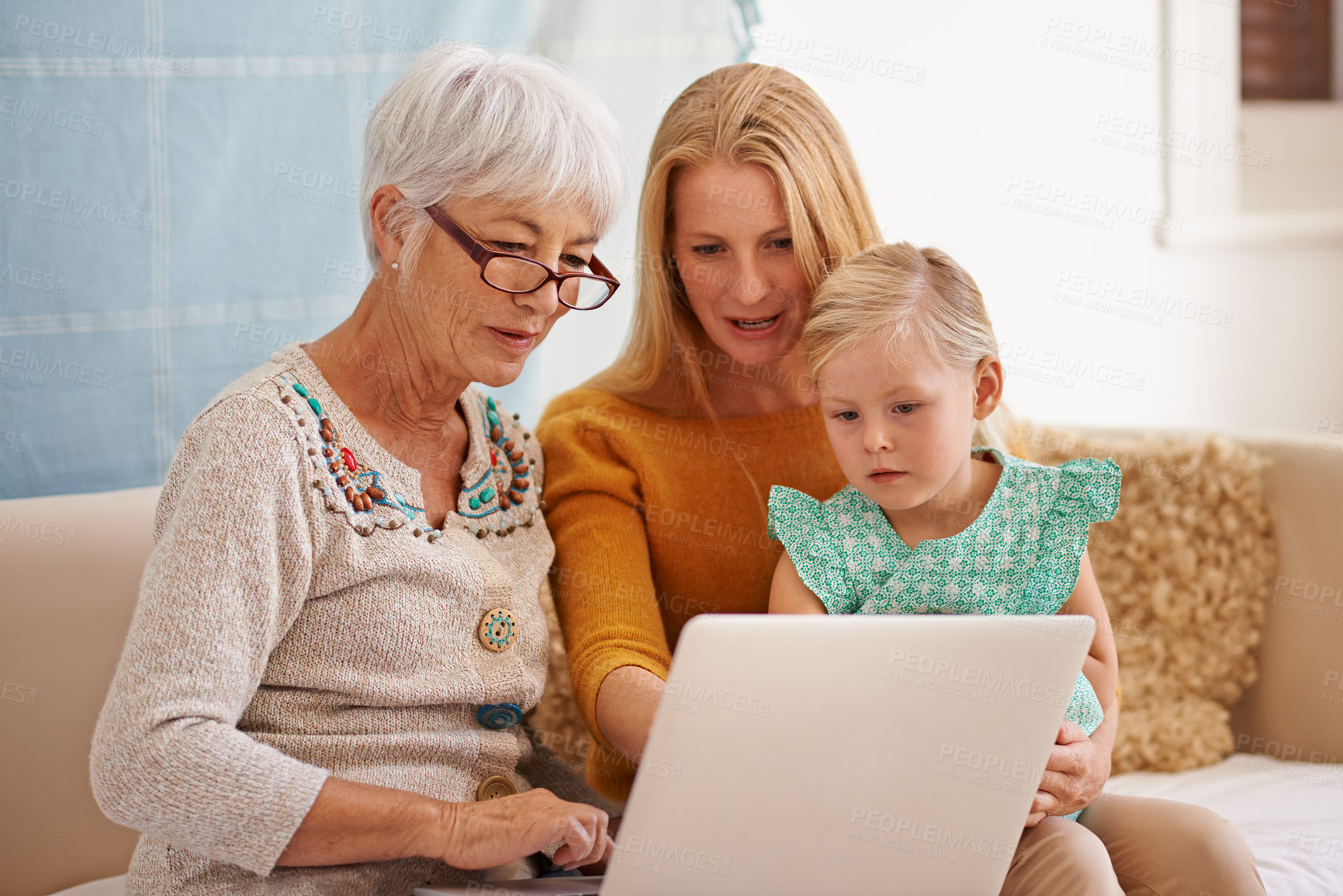 Buy stock photo Cropped shot of a young woman and her daughter sitting with a laptop indoors