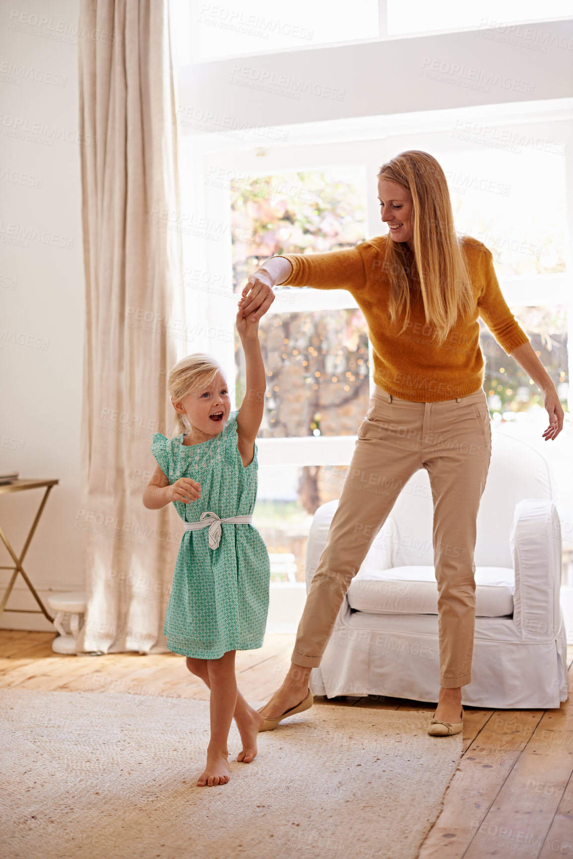 Buy stock photo Full-length shot of a young woman playfully dancing with her little girl