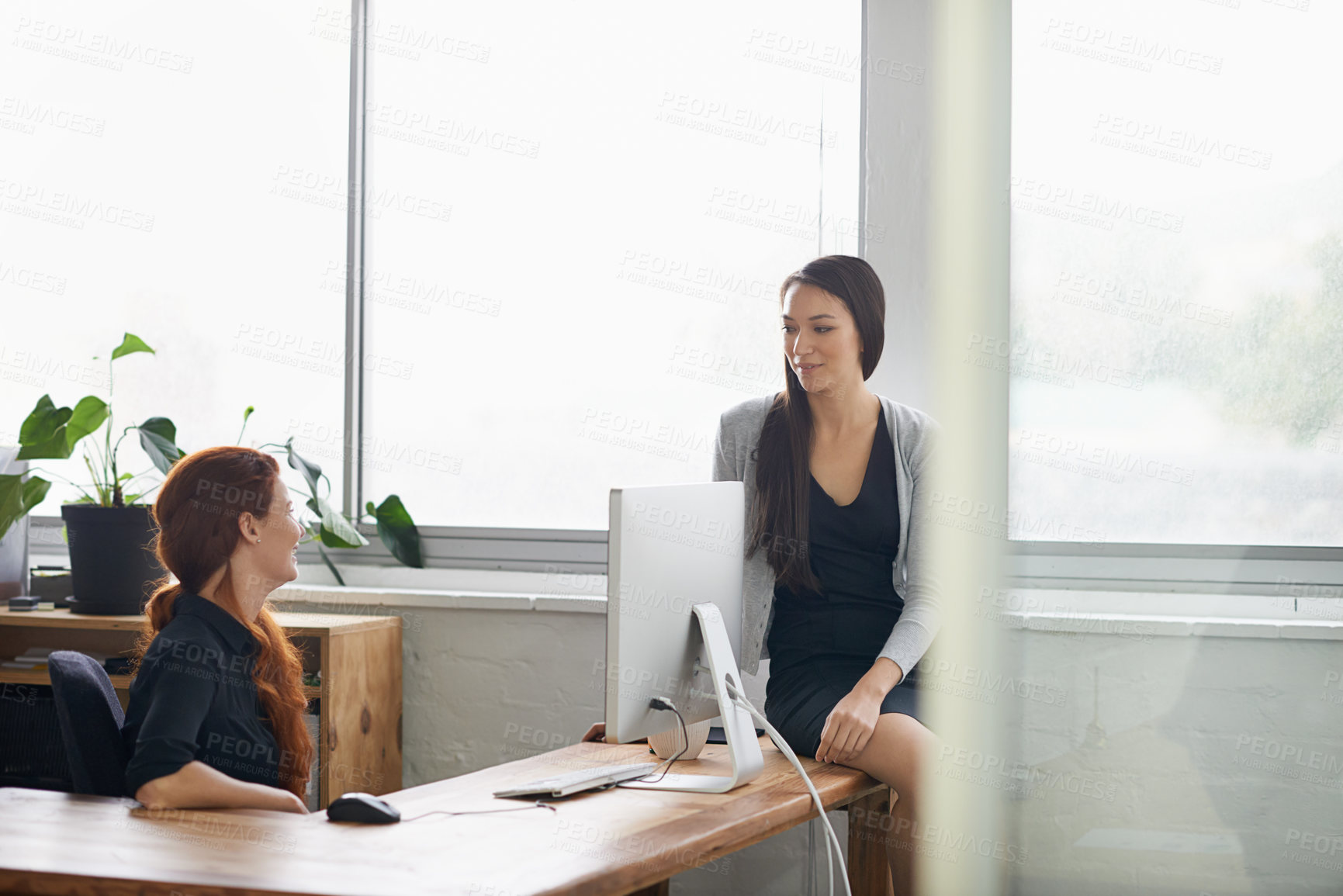Buy stock photo Talking, friends and business women in office speaking, chatting and in discussion at desk. Communication, collaboration and female workers enjoy casual conversation on break, relaxing and happy