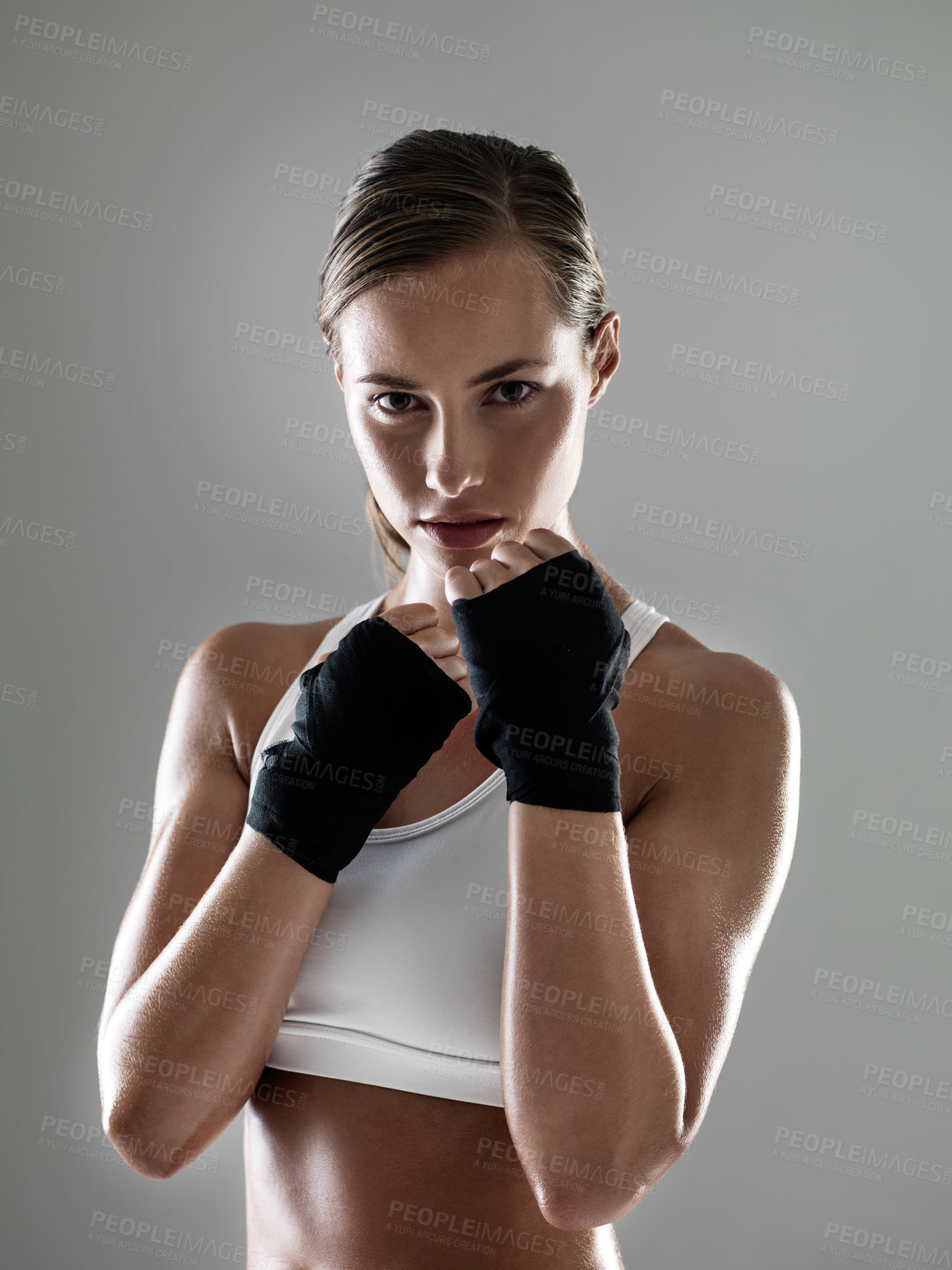 Buy stock photo Serious woman, portrait and boxer with fist straps in fitness, fight or workout exercise on a gray studio background. Young female person or fighter ready for practice, competition or sports training