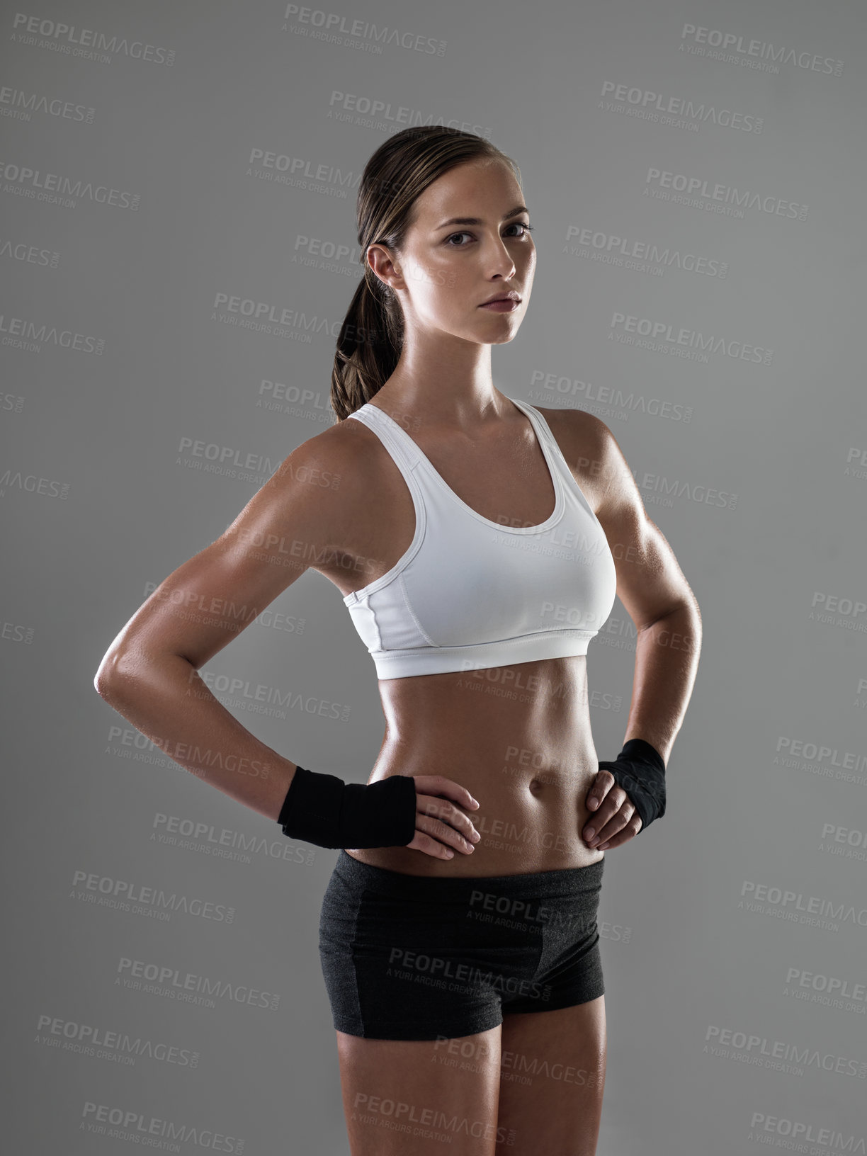 Buy stock photo Shot of an athletic woman in workout clothes standing with her hands on her hips