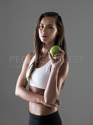 Buy stock photo Portrait, apple and woman with nutrition, fitness and wellness on a grey studio background. Face, person and model with fruit and gut health with diet plan and balance with benefits and digestion