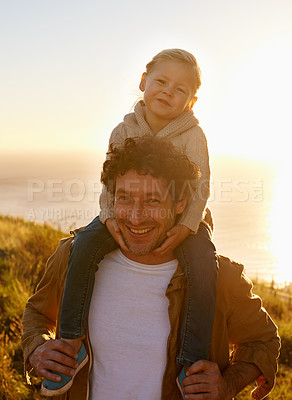 Buy stock photo Portrait of a father giving his little girl a ride on his shoulders while on a walk in nature