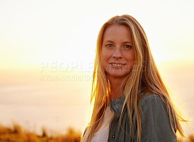 Buy stock photo Portrait of a beautiful young woman standing outside at sunset