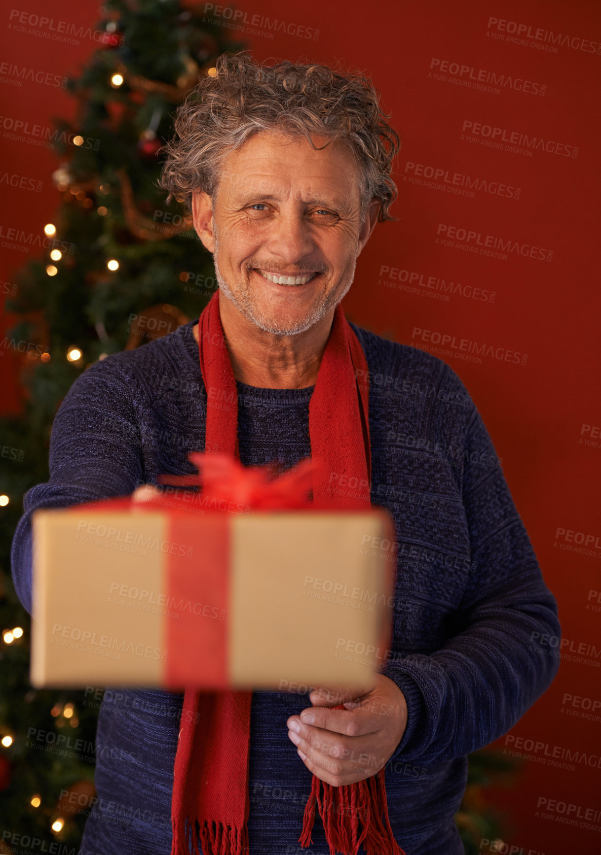 Buy stock photo Shot of a mature man handing a gift to the viewer