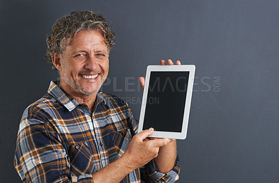 Buy stock photo Tablet, screen and portrait of mature man in studio and learning about technology on dark background. Advertising, tech and mockup with post online to social media and person search internet for news