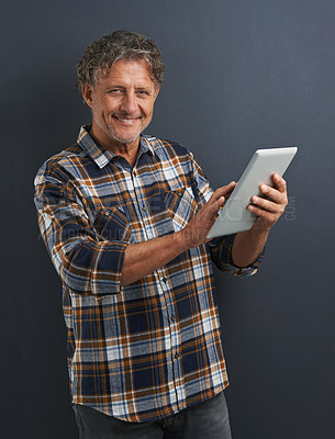 Buy stock photo Reading, tablet and portrait of mature man in studio and learning about technology on dark background. Information, tech and mockup with post online to social media or person search internet for news