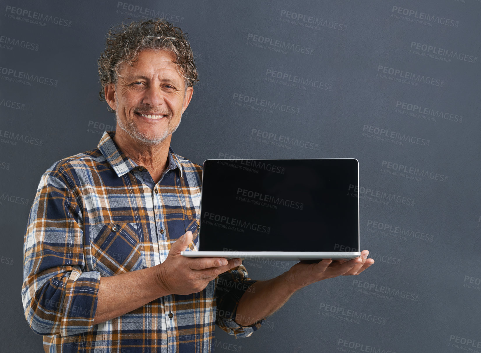 Buy stock photo Laptop, screen and portrait of mature man in studio and learning about technology on dark background. Advertising, computer and mockup with online post to social media and search internet for news