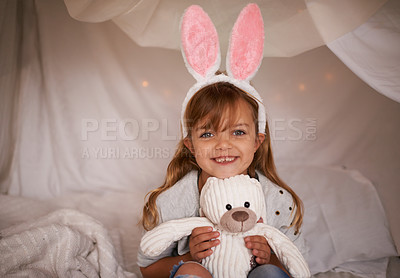 Buy stock photo Girl, child and bunny ears with teddy bear, soft toys and playing in fort for camping and fun at family home. Happiness, innocent and kid with stuffed animal, games for Easter and joy in childhood