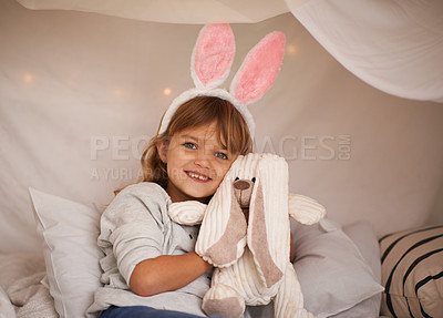 Buy stock photo Girl, kid and bunny ears with teddy bear, soft toys and playing in fort for camping and fun at family home. Happiness, innocent and child with stuffed animal, games for Easter and fun in childhood