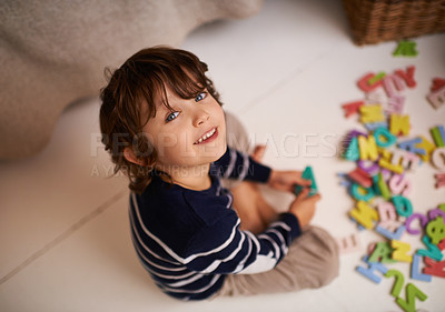 Buy stock photo Portrait of an adorable little boy playing with colorful toy letters