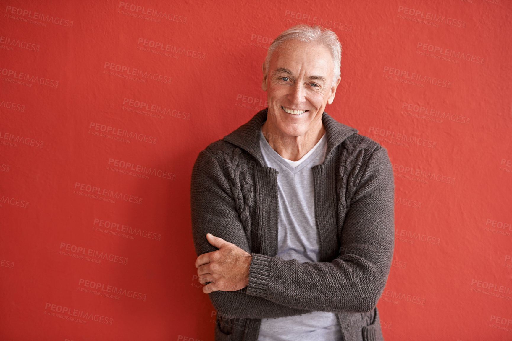 Buy stock photo Happy senior man, portrait and red background in retirement with smile, arms crossed and fashion. Elderly guy, happiness and confidence by wall with excited face for lifestyle, experience and relax