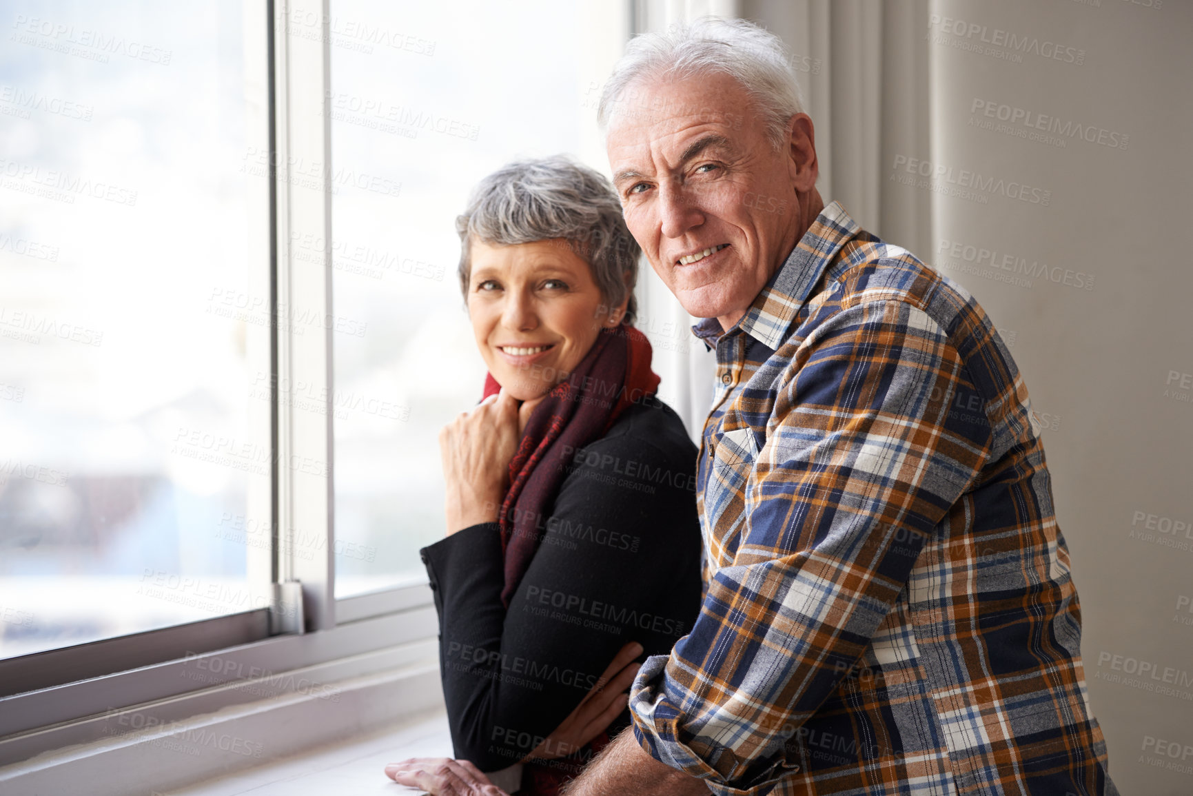 Buy stock photo Portrait of a senior couple enjoying an affectionate moment by the window