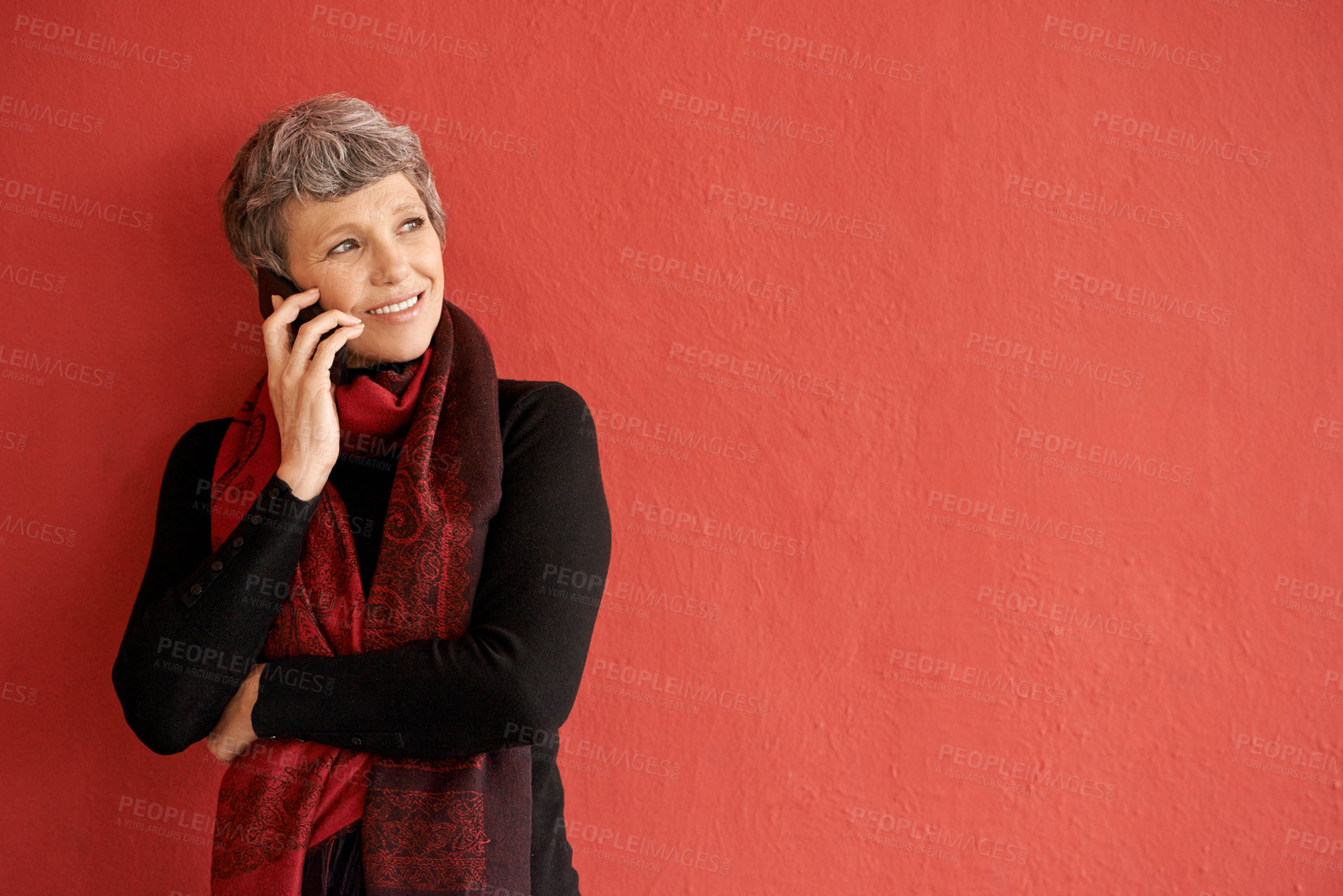 Buy stock photo Mature woman, phone call and smile by wall with space for mockup, communication and listen by red background. Senior lady, smartphone and think of idea in mock up for chat, networking and talking