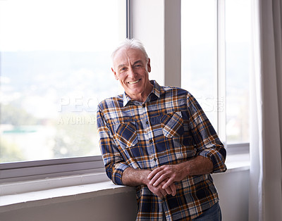 Buy stock photo Portrait of a handsome senior man standing in front of a window on a bright day