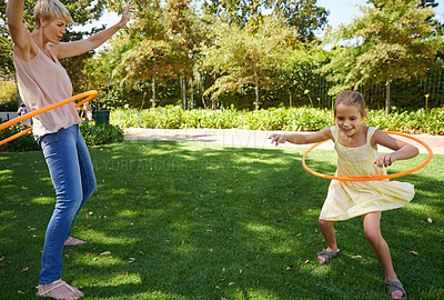 Buy stock photo Mother, child and hula hoop for outdoor fun in backyard garden for parenting bonding, summer or holiday vacation. Woman, daughter and recreation connection on grass for playing, carefree or happy