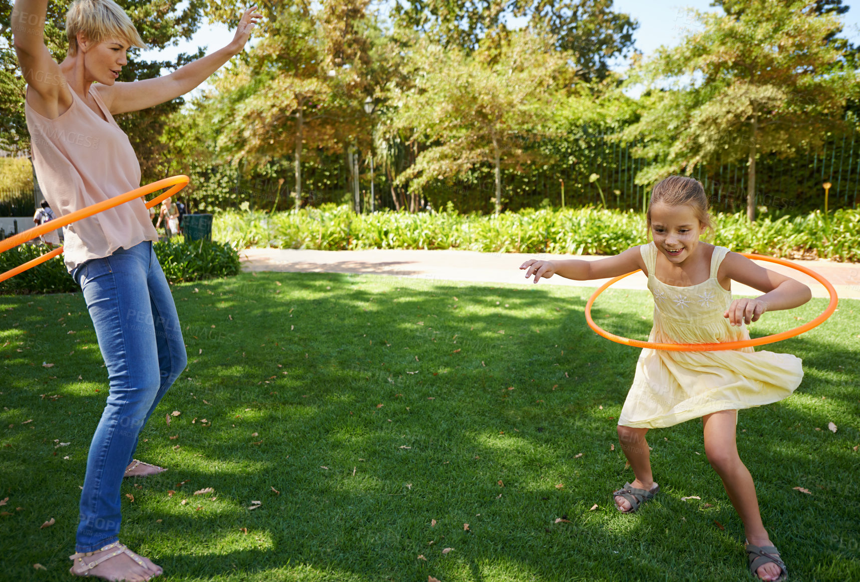 Buy stock photo Mother, child and hula hoop for outdoor fun in backyard garden for parenting bonding, summer or holiday vacation. Woman, daughter and recreation connection on grass for playing, carefree or happy
