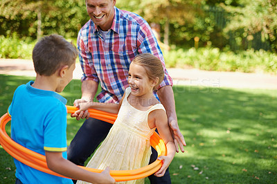 Buy stock photo Father, kids and hula hoop in park for playing, child development and motor skills outdoor. Children, son and daughter with dad in nature for leisure, family time and bonding with smile on grass