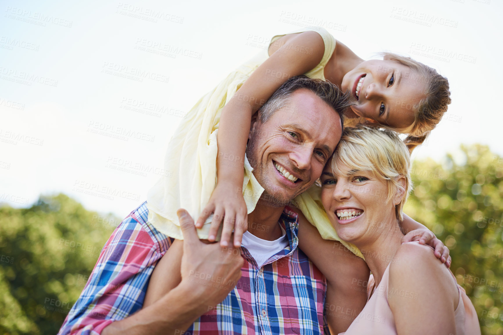 Buy stock photo A cropped portrait of two happy parents with their young daughter standing outdoors