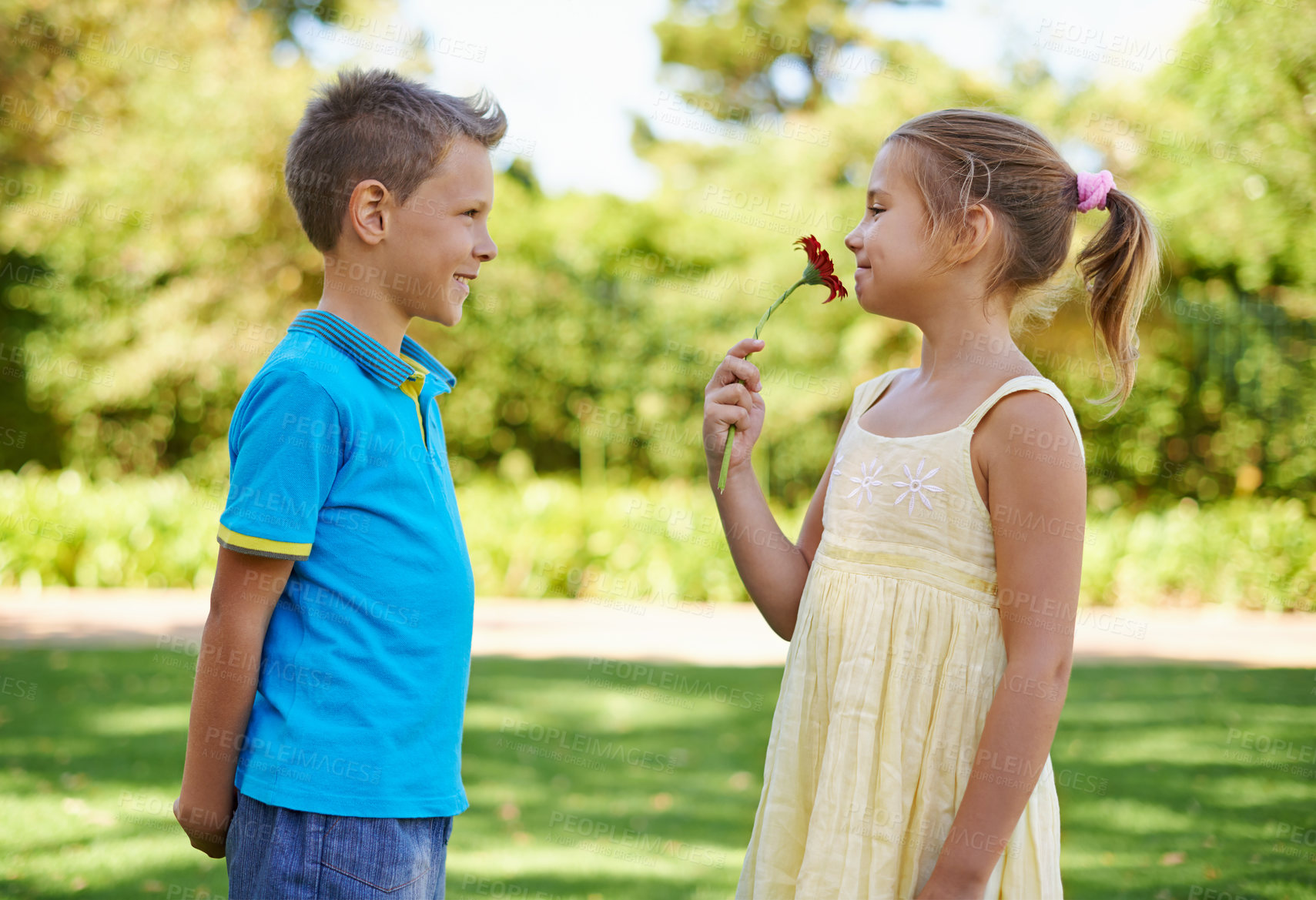 Buy stock photo Children, friends and flower gift or outdoor connection with love kindness or young care, bonding or innocent. Boy, girl and smile at backyard garden for smell plant or summer holiday, play or park