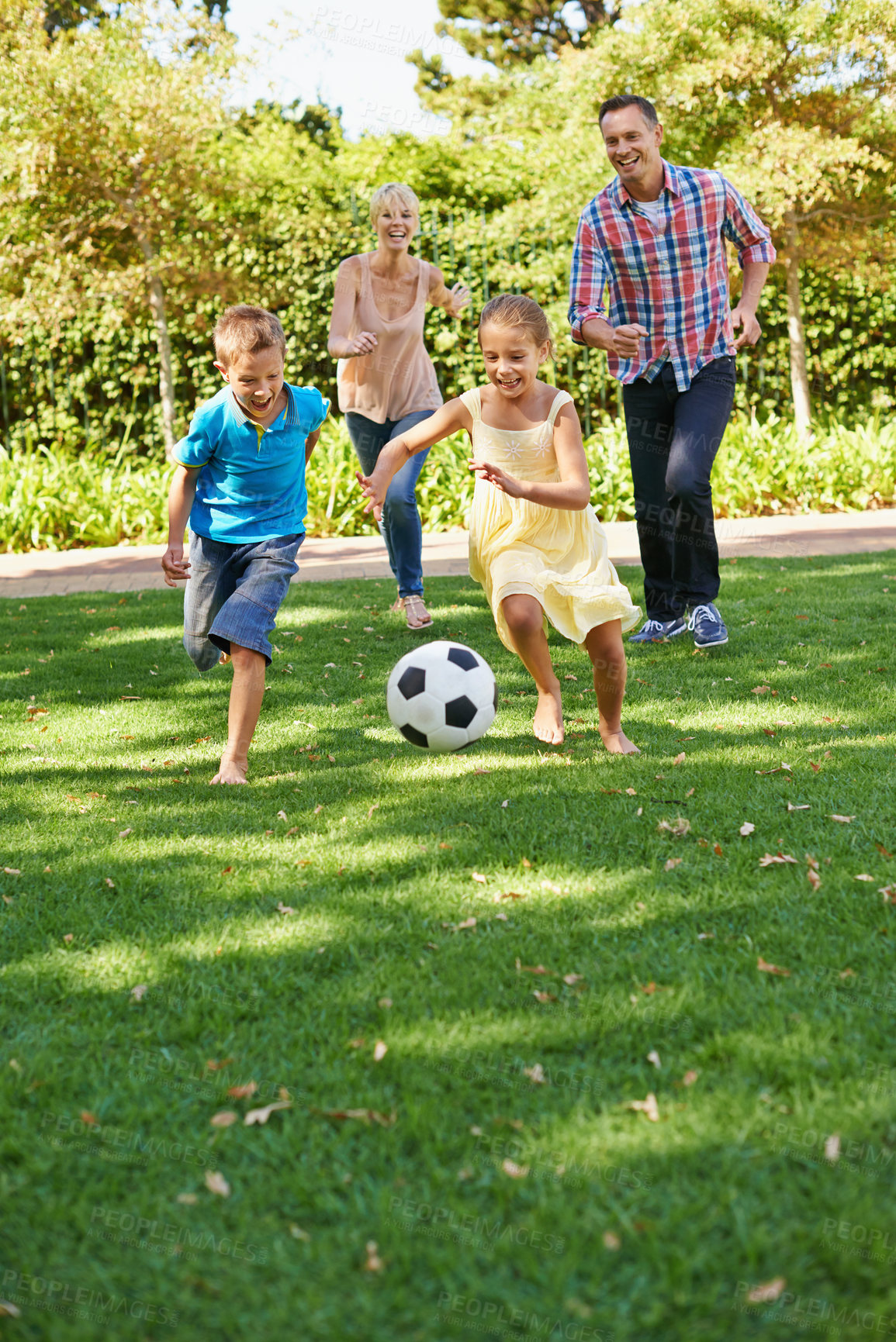 Buy stock photo A happy family playing soccer in the park on a beautiful summer day
