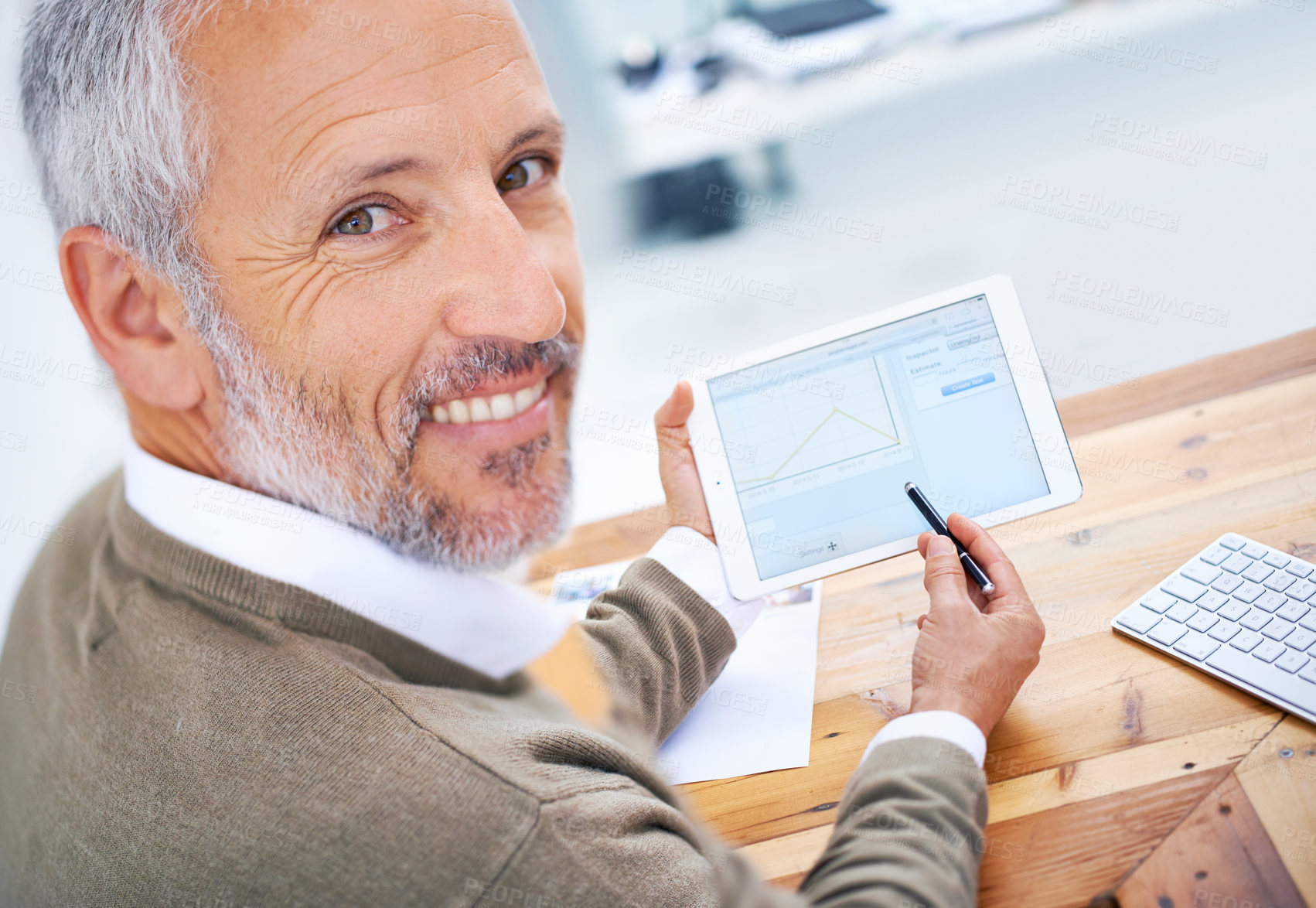 Buy stock photo A portrait of a happy businessman using a tablet at his desk